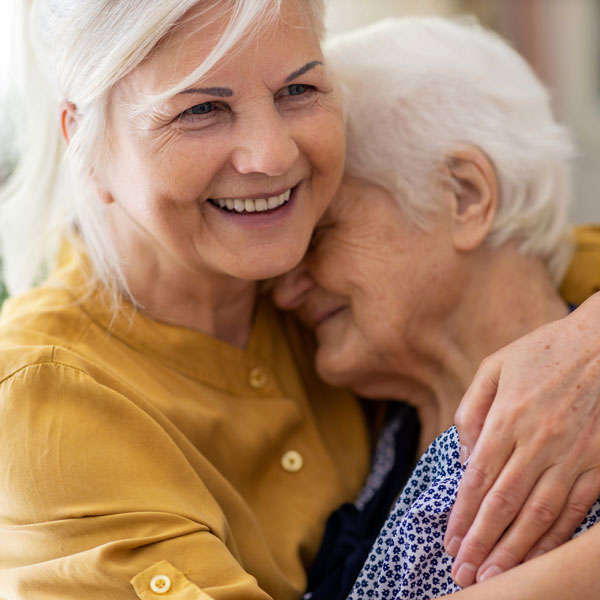 elderly mom and daughter hugging