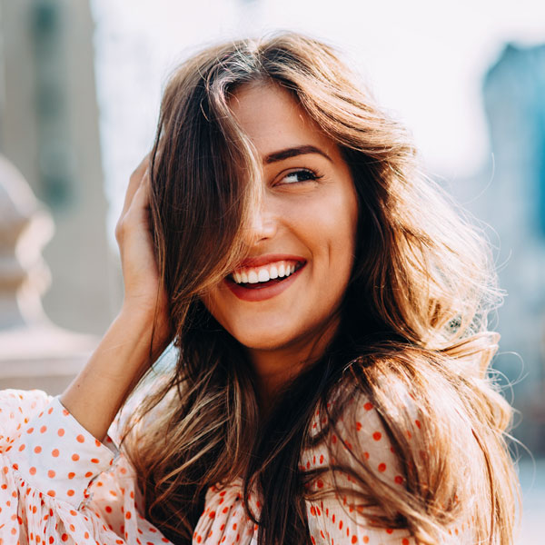 woman smiling with hair over one eye